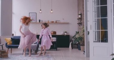 Neşeli anne ev hareketli en sevdiğiniz şarkıda birlikte dans, oturma odasında duran küçük kızı. Çocuk sahibi eğlenceli ablası ile dadı ya da sevgi dolu anne aktif eğlence ve yaşam tarzı kavramı