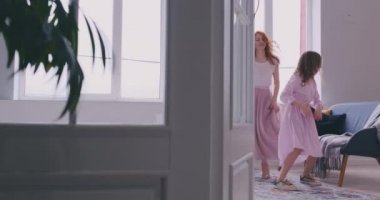 Aktif aile genç anne dans küçük okul öncesi veya okul çağında kız ablası ile eğlenmek mutlu şarkı birlikte hareket dinler, çocuk olumlu duygular kavramı ile boş zaman etkinlikleri