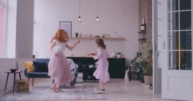 Anne kızıyla odada dans ediyor.