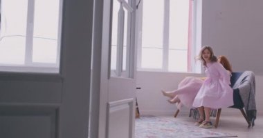 Neşeli anne ev hareketli en sevdiğiniz şarkıda birlikte dans, oturma odasında duran küçük kızı. Çocuk sahibi eğlenceli ablası ile dadı ya da sevgi dolu anne aktif eğlence ve yaşam tarzı kavramı