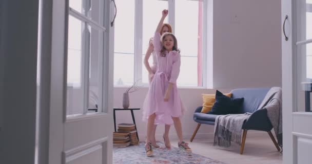 Aktive junge Mutter Babysitter und niedliche kleine Tochter springen tanzen in modernen Haus Wohnzimmer, glückliche Familienmutter mit Kind Mädchen Spaß genießen lustige Aktivitäten zusammen zu Hause — Stockvideo