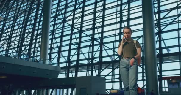 Dívčí cestovatel na letišti, aby si promluvil na mobilním telefonu — Stock video