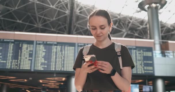 Женщина смотрит на экран мобильного телефона, чтобы найти ваш электронный билет в самолете — стоковое видео