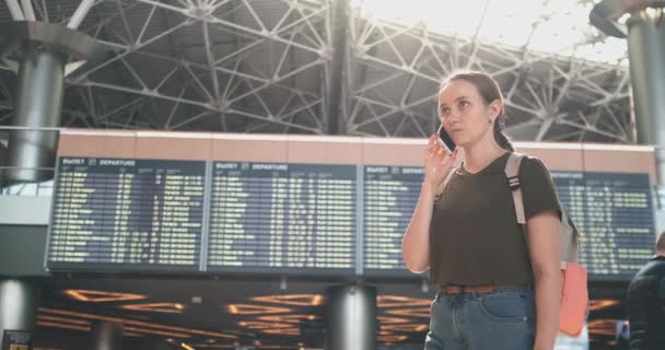 Reisendes Mädchen am Flughafen, um mit einem Handy zu sprechen — Stockvideo