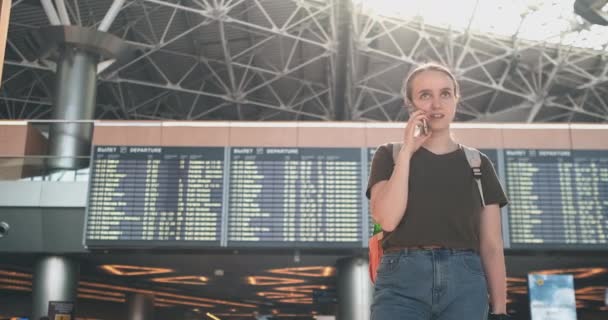 Reisendes Mädchen am Flughafen, um mit einem Handy zu sprechen — Stockvideo