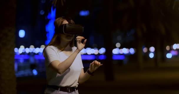 Chica joven en gafas de realidad virtual en una gran metrópoli — Vídeo de stock