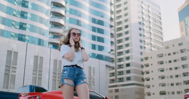 Joven hermosa mujer hablando por teléfono en el fondo de los edificios — Vídeos de Stock