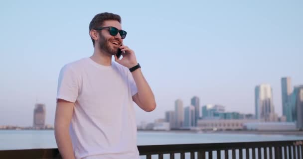 Un homme en lunettes de soleil d'été parlant au téléphone — Video