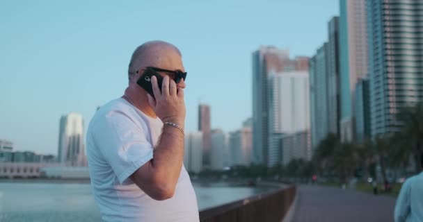 Uomo anziano in piedi sul lungomare in estate a parlare al telefono — Video Stock