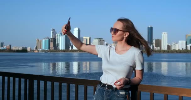 Kaukasische Frau macht Selfies per Handy, draußen in Dubais Yachthafen bei schönem Wetter — Stockvideo