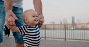 Gülümseyen mutlu gülen bebek rıhtımda yaz aylarında ilk adımlarını atıyor