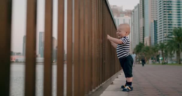 Lächelnd fröhlich lachendes Baby tanzt im Sommer am Wasser — Stockvideo