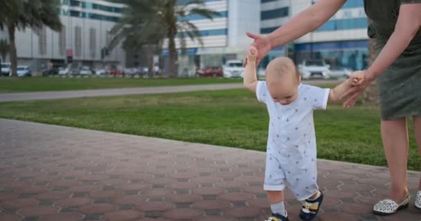 Niño 1 año está aprendiendo paseos, riendo y sonriendo con la abuela — Vídeos de Stock