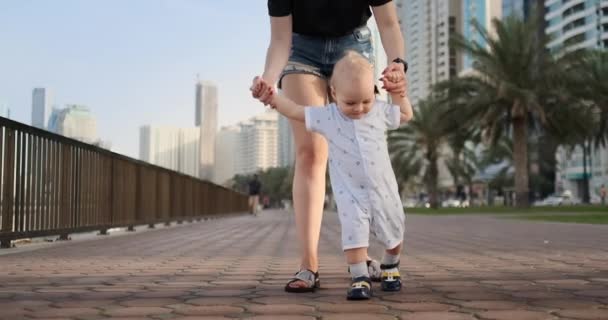 In de zomer een jonge moeder wandelen met een kind langs de promenade — Stockvideo