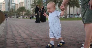 Oğlan 1 yıl yürüyüş öğrenme, gülüyor ve Büyükanne ile gülümsüyor