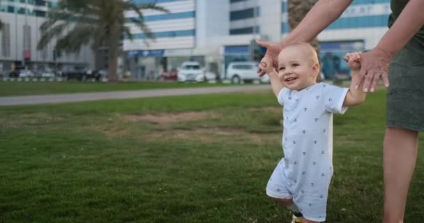 Sorrindo menino close-up com a idade de 1 ano aprender a andar fazendo os primeiros passos — Vídeo de Stock