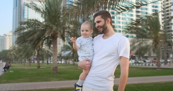 Pai brincando com filhos no verão em torno de palmeiras e edifícios — Vídeo de Stock