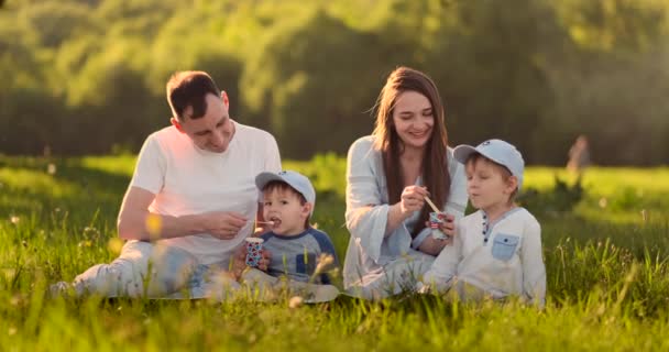 Rodina 4 2 dětí a rodičů v létě sní zmrzlinu na pikniku — Stock video
