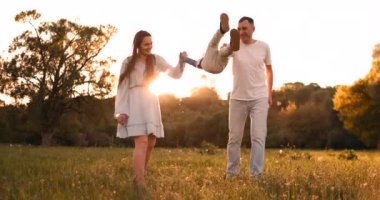 Anne ve baba elleri üzerinde oynarken çocuk sallamak, çocuk gün batımında sokakta anne ve babası ile oynarken mutlu