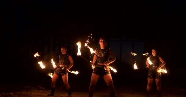 Espectáculo de bomberos profesional en el antiguo hangar de la aeronave muestran artistas profesionales del circo tres mujeres en trajes de cuero y un hombre con dos lanzallamas . — Vídeo de stock