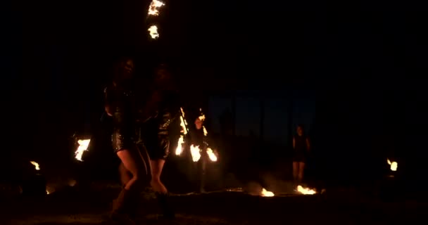 Spectacle d'incendie professionnel dans le vieux hangar de l'avion montrent des artistes de cirque professionnels trois femmes en costume de cuir et un homme avec deux lance-flammes . — Video