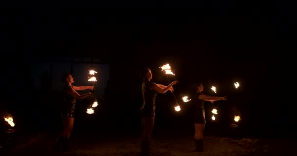 Eine Gruppe professioneller Künstler mit Feuershow, die mit Feuer jongliert und in Zeitlupe tanzt. — Stockvideo