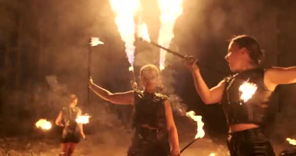 Cámara lenta: espectáculo de fuego en el hangar muestran tres artista femenina y un hombre con lanzallamas . — Vídeos de Stock