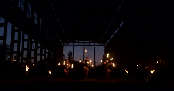 Cuatro mujeres en ropa de cuero con baile de fuego y espectáculo de fuego muestran a un hombre con un lanzallamas en la espalda juega con la llama en cámara lenta . — Vídeos de Stock