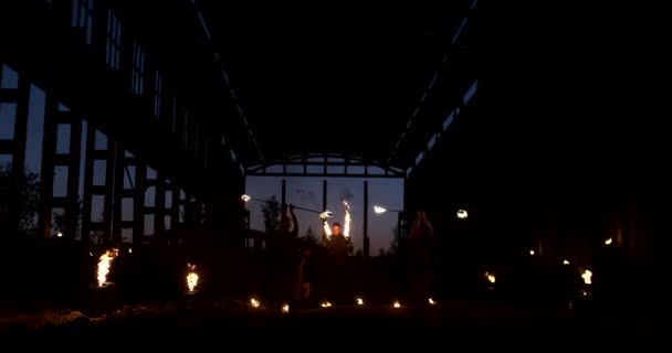 四个穿着皮衣的妇女，跳着火舞，表演着火，显示一个在后面放火焰的男人在慢动作下与火焰玩耍. — 图库视频影像