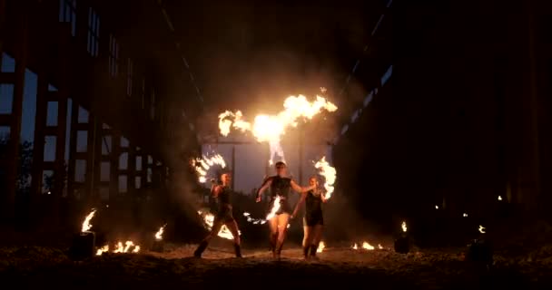 Slow Motion: Fire show in de hangar show drie vrouwelijke artiest en een man met vlammenwerpers. — Stockvideo