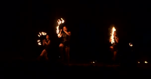 Група пожежних жонглерів. Люди плюють вогонь у темну ніч на відкритому повітрі — стокове відео