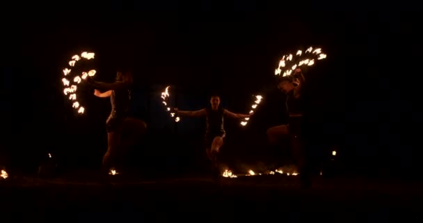 Grupo de malabaristas de fuego. La gente escupe fuego en una noche oscura al aire libre — Vídeo de stock