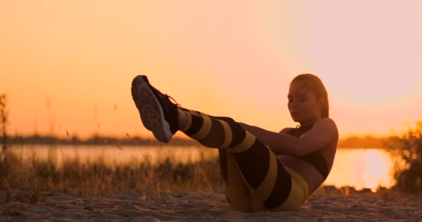 Stark ung kvinna gör en medicin boll träning på sanddyner. Idrottare med rotation för konditionsträning i öknen — Stockvideo