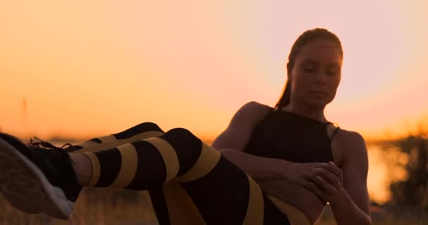 Fitness-Frau beim Knirschen am Strand. Fitness-Frau beim Crunch-Workout in Richtung Strand. Fitte Athletin trainiert Bauch-Mittelteil. — Stockvideo