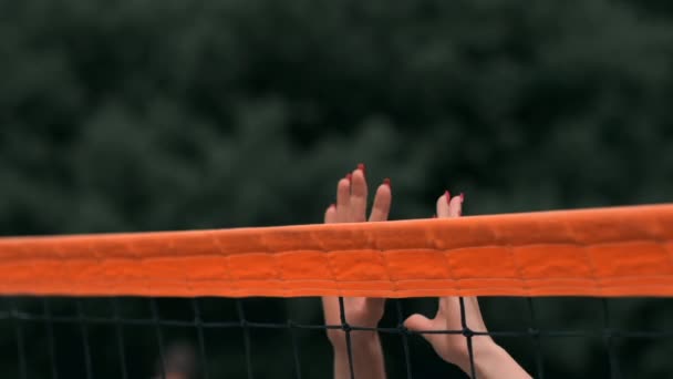 Zeitlupe, Großaufnahme, niedriger Winkel: Unerkennbare junge Frauenhände spielen Volleyball am Netz. Offensivspieler spitzelt den Ball und der Gegner blockt ihn direkt über das Netz. — Stockvideo