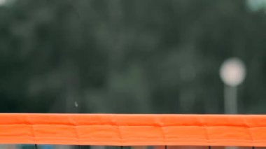 Yavaş Hareket, Yakın Çekim, Düşük Açı: Ağda voleybol oynayan tanınmayan genç kadın elleri. Hücum oyuncusu topu çiviler ve rakip bir turnuva sırasında topu sağ üstten engeller.