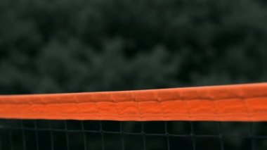 Yavaş Hareket, Yakın Çekim, Düşük Açı: Ağda voleybol oynayan tanınmayan genç kadın elleri. Hücum oyuncusu topu çiviler ve rakip bir turnuva sırasında topu sağ üstten engeller.