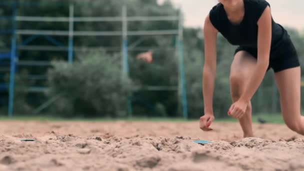Jonge vrouwelijke atleet duikt in het zand en bespaart een punt tijdens beachvolleybal wedstrijd. Vrolijk Kaukasische meisje springt en crasht in het witte zand tijdens een beachvolleybal toernooi — Stockvideo