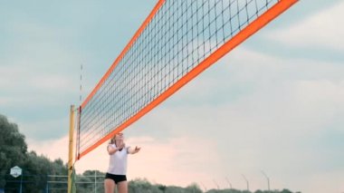 Dört kız voleybolcular kum üzerinde yavaş çekim de turnuvaya katılan yaz aylarında plajda oynamak.