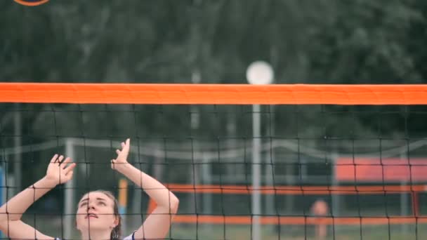 Las mujeres sirven voleibol. Mujer preparándose para servir el voleibol mientras está de pie en la playa en cámara lenta . — Vídeos de Stock