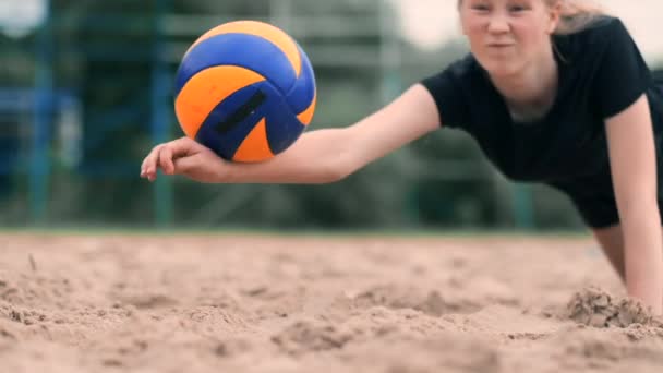 Kvinnlig volleybollspelare i höst träffar bollen i slow motion på stranden. — Stockvideo