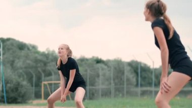 Sahilde voleybol oynayan dört kız. Plaj voleybolu, file, bikinili kadınlar. Düz karikatür illüstrasyon. Oyunu başlatın, topu tutan kız