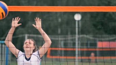 Profesyonel voleybol plaj turnuvasında kadın hizmet vermektedir. Voleybol net oyuncu uygularken görünümü engeller