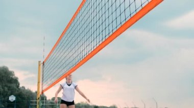 Profesyonel Plaj Voleybolu Turnuvasında Yarışan Kadınlar. Bir defans oyuncusu 2 kadın uluslararası profesyonel plaj voleybolu sırasında bir atış durdurmak için çalışır