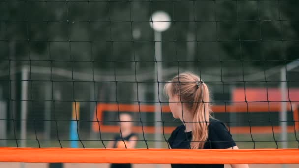 Las mujeres sirven voleibol. Mujer preparándose para servir el voleibol mientras está de pie en la playa en cámara lenta . — Vídeo de stock