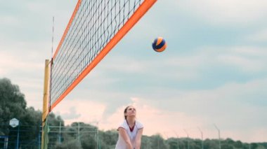 Profesyonel Plaj Voleybolu Turnuvasında Yarışan Kadınlar. Bir defans oyuncusu 2 kadın uluslararası profesyonel plaj voleybolu sırasında bir atış durdurmak için çalışır