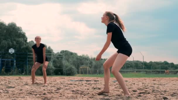 Mulheres competindo em um torneio profissional de vôlei de praia. Um defensor tenta parar um tiro durante o vôlei de praia profissional internacional de 2 mulheres — Vídeo de Stock