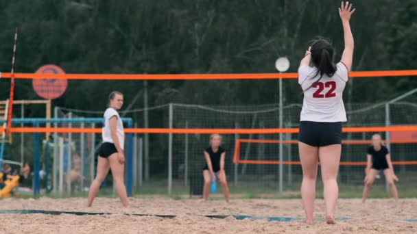 महिला व्हॉलीबॉल सर्व्ह करा. समुद्रकिनारावर हळू चळवळ उभे असताना व्हॉलीबॉल सेवा करण्यास तयार होणारी स्त्री . — स्टॉक व्हिडिओ