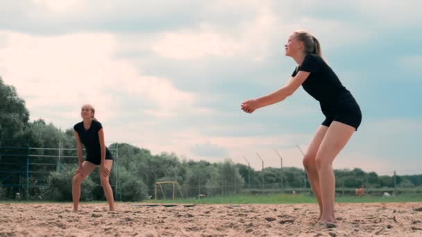 Літні канікули, спорт і концепція людей - молода жінка з м'ячем грає у волейбол на пляжі . — стокове відео