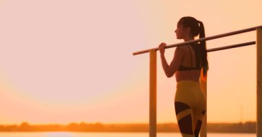 Tema kadın spor ve sağlık. Kıvırcık uzun saçlı, açık hava spor sahasında poz veren güzel beyaz kadın. Tema kadın spor ve sağlık.